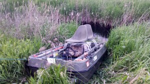 Using the blue dog leash visible on the left front of the boat, we drag her out of the side slough. Everything is a muddy mess, including us.